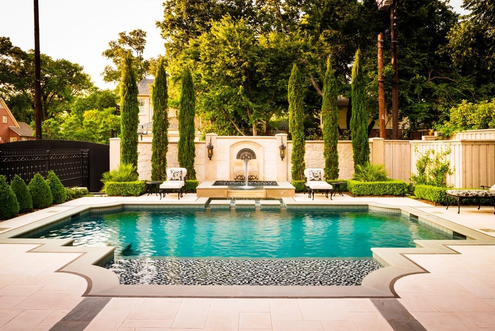 Photo of a mid-sized traditional backyard custom-shaped pool in Dallas with natural stone pavers and a hot tub.