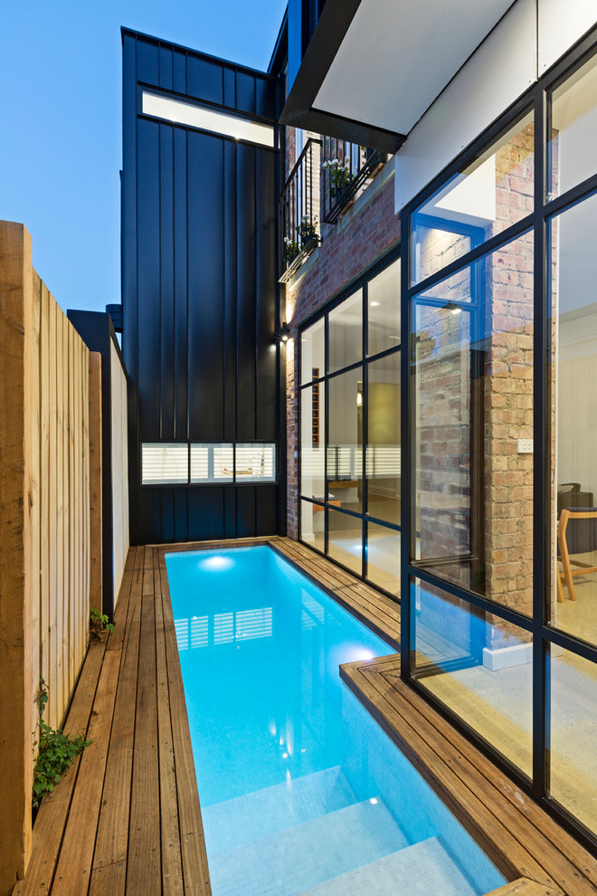 Small contemporary side yard rectangular pool in Melbourne with decking.