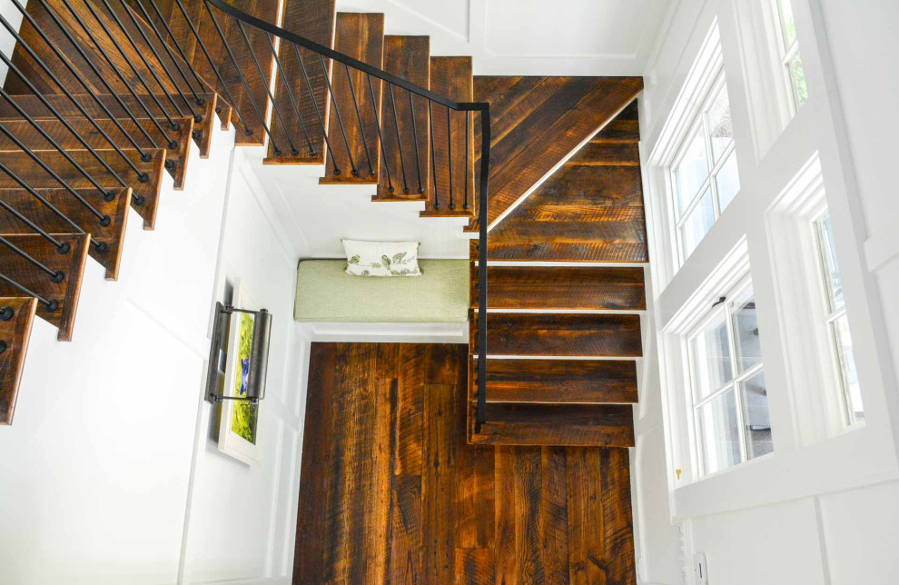 Идея дизайна: лестница с деревянными ступенями, крашенными деревянными подступенками, металлическими перилами и панелями на части стены