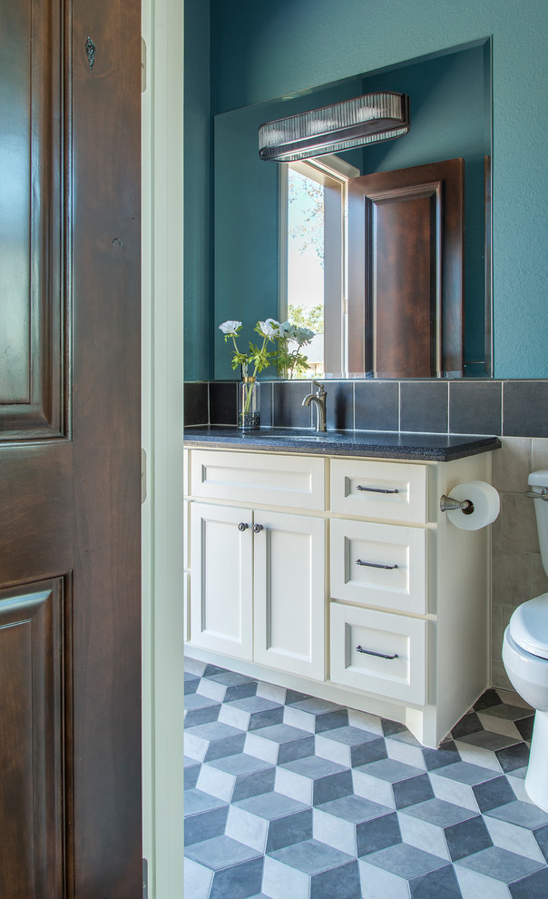 This is an example of a mid-sized contemporary 3/4 bathroom in Other with shaker cabinets, white cabinets, a one-piece toilet, black tile, ceramic tile, blue walls, ceramic floors, an undermount sink, quartzite benchtops, blue floor, black benchtops, a single vanity and a built-in vanity.