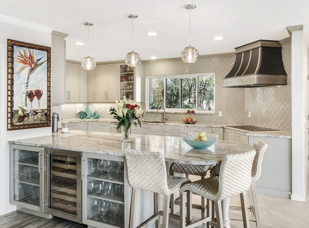 Example of a classic beige floor kitchen design with granite countertops, a peninsula, an undermount sink, recessed-panel cabinets, beige cabinets and beige backsplash