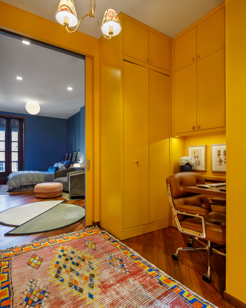 Idées déco pour un bureau contemporain de taille moyenne avec un mur jaune, un sol en bois brun, aucune cheminée, un bureau intégré et un sol marron.