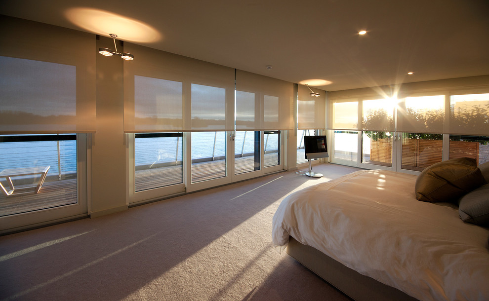 Photo of a large contemporary master bedroom in Surrey with carpet and no fireplace.