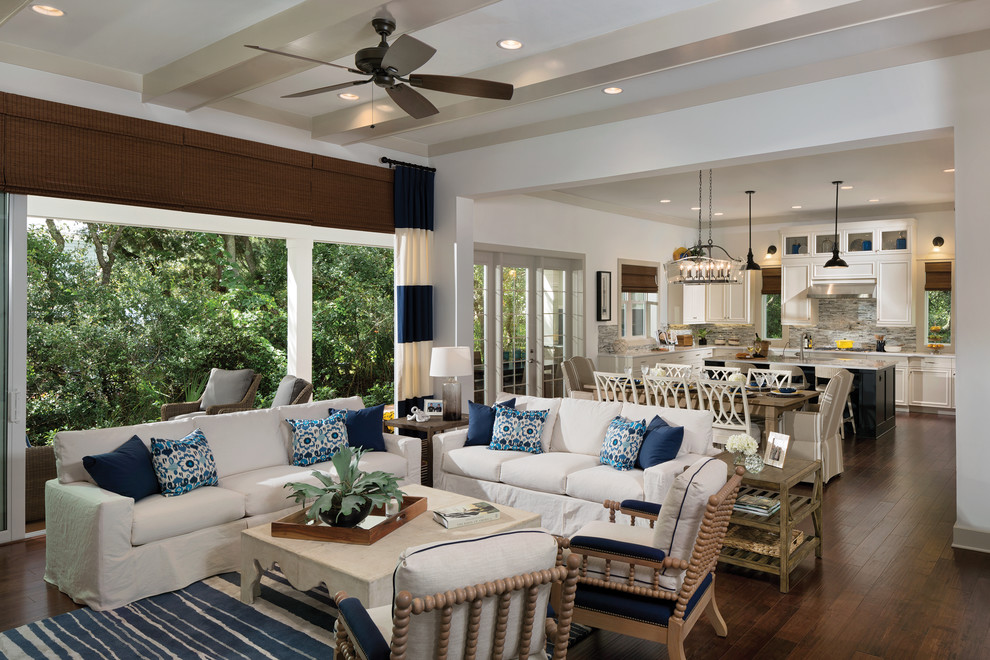 This is an example of an expansive beach style open concept family room in Tampa with white walls, medium hardwood floors and a wall-mounted tv.