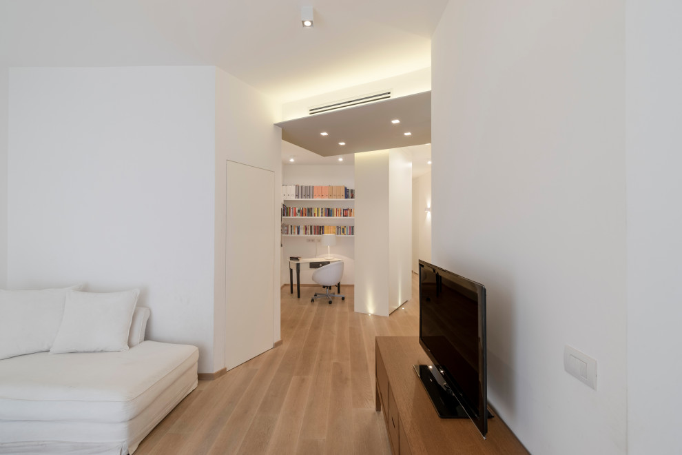This is an example of a contemporary entryway with white walls, light hardwood floors and beige floor.