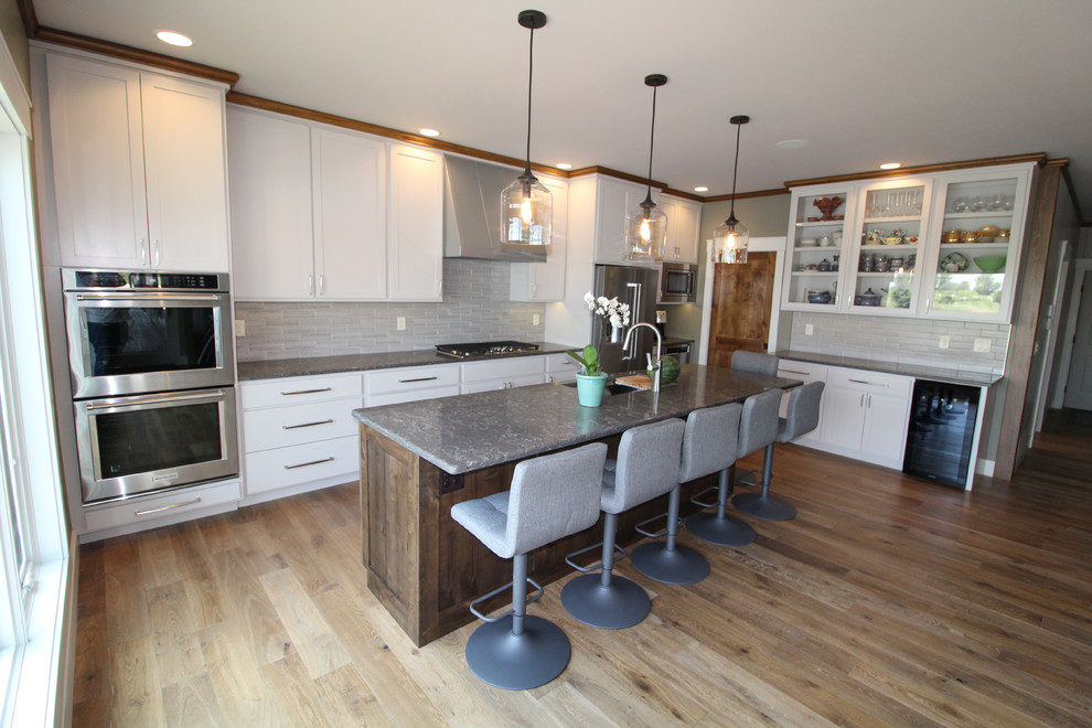 Kitchen - kitchen idea with an undermount sink, shaker cabinets, medium tone wood cabinets, quartz countertops, stainless steel appliances, an island and gray countertops