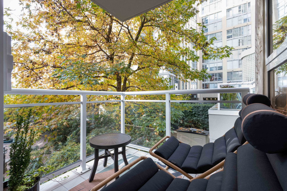 Inspiration for a small contemporary balcony for for apartments in Vancouver with a roof extension and mixed railing.