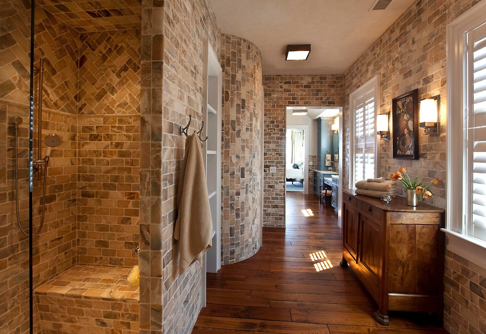 Inspiration for a transitional bathroom in Charleston with medium wood cabinets, a corner shower, stone tile and brown tile.