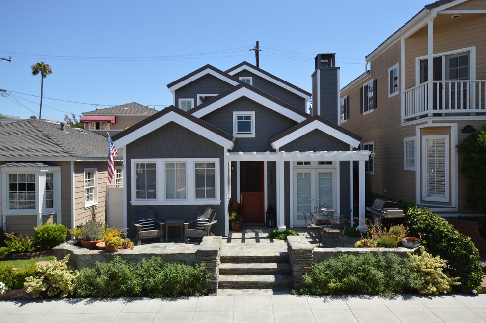 Inspiration for a mid-sized beach style two-storey grey house exterior in Los Angeles with a gable roof, wood siding, a shingle roof, a black roof and shingle siding.