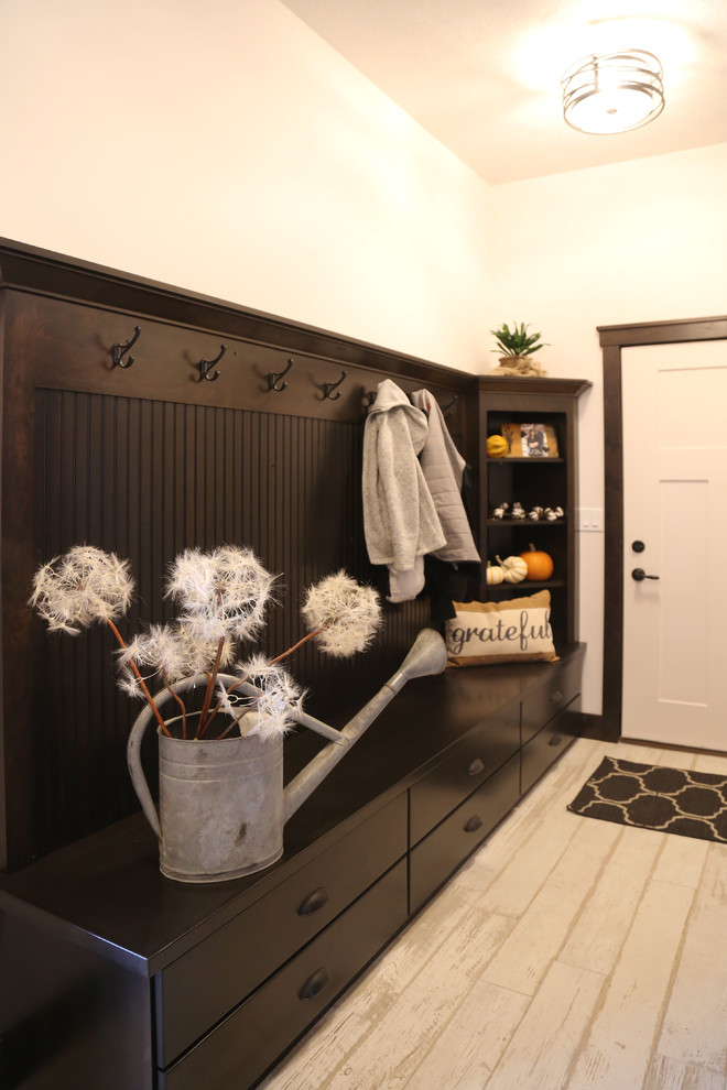 Small transitional porcelain tile mudroom photo with white walls and a white front door