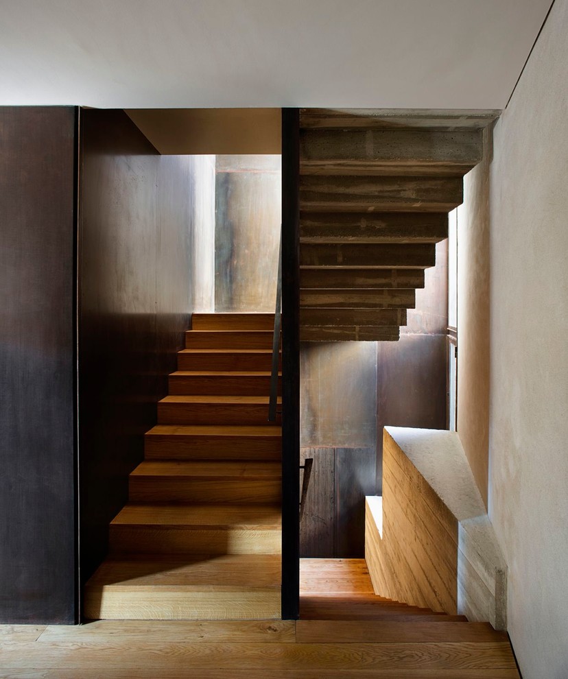 This is an example of a mid-sized contemporary wood u-shaped staircase in Barcelona with wood risers.
