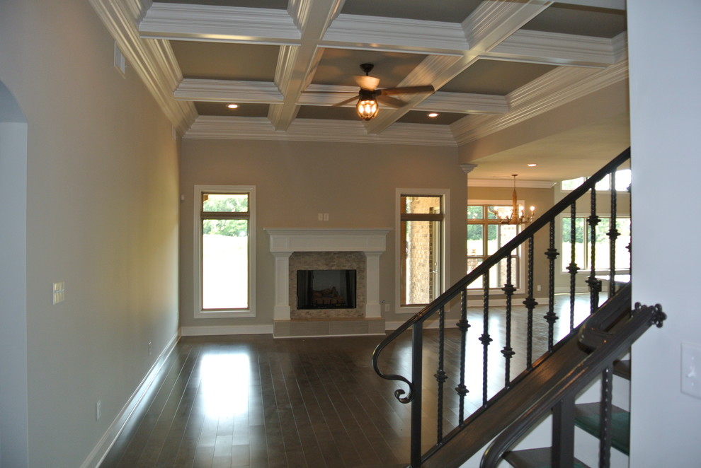Example of a transitional medium tone wood floor home design design with gray walls, a standard fireplace and a tile fireplace