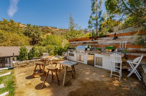 Hillside outdoor kitchen with stainless appliances and RTA cabinets—showing why outdoor-rated materials matter