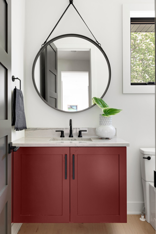 This is an example of a bathroom in Minneapolis with red cabinets, light hardwood floors, a drop-in sink, engineered quartz benchtops, a single vanity and a floating vanity.