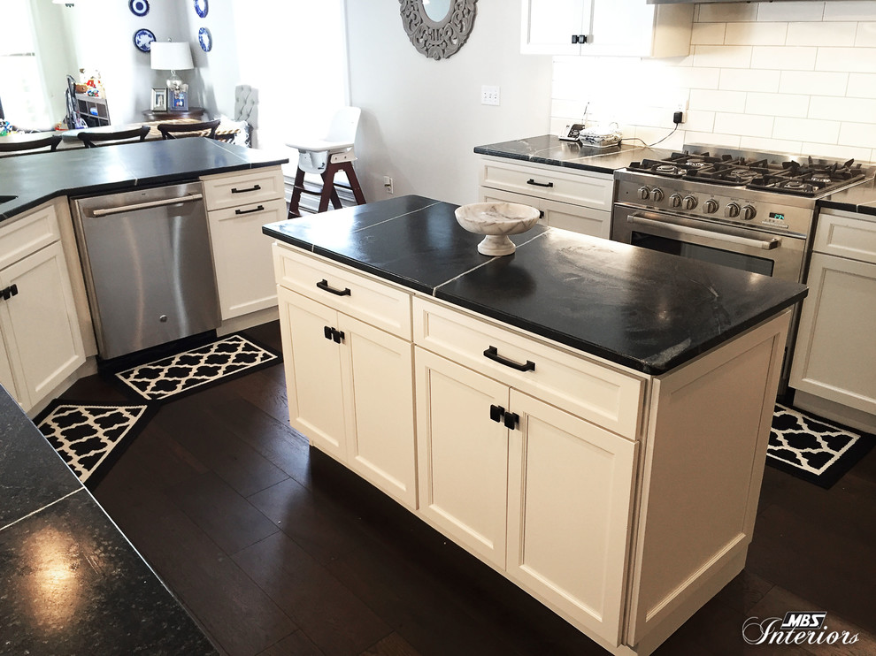 Inspiration for a mid-sized transitional u-shaped dark wood floor and brown floor eat-in kitchen remodel with an undermount sink, recessed-panel cabinets, white cabinets, soapstone countertops, white backsplash, subway tile backsplash, stainless steel appliances and an island