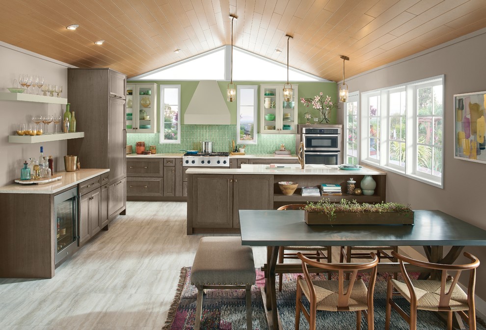 Transitional l-shaped eat-in kitchen in Other with recessed-panel cabinets, medium wood cabinets, green splashback, stainless steel appliances, a peninsula and grey floor.