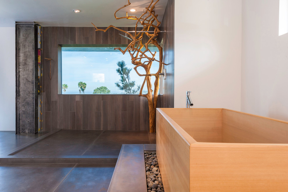 Photo of an expansive asian master bathroom in San Diego with a japanese tub, an open shower, gray tile, cement tile, white walls, concrete floors, grey floor, an open shower, flat-panel cabinets, black cabinets, a one-piece toilet, a trough sink and wood benchtops.
