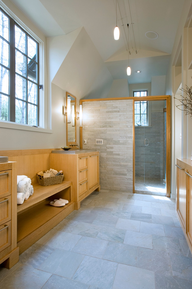 This is an example of a large contemporary master bathroom in Charlotte with beaded inset cabinets, beige cabinets, a freestanding tub, an alcove shower, a one-piece toilet, gray tile, slate, grey walls, slate floors, an integrated sink, concrete benchtops, grey floor and a hinged shower door.