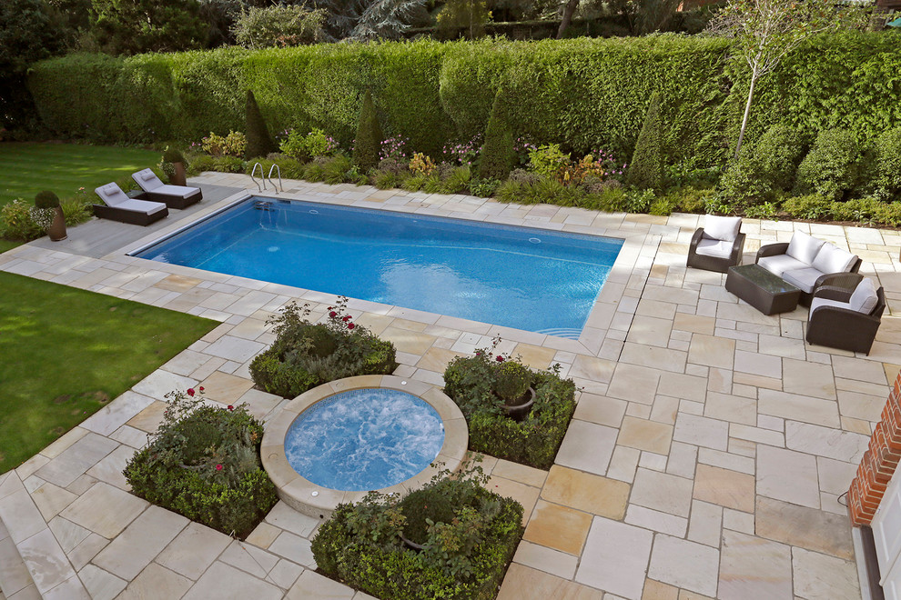 Large traditional backyard rectangular pool in Surrey with a hot tub and tile.
