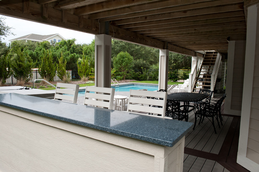 Mid-sized beach style backyard deck photo with a roof extension