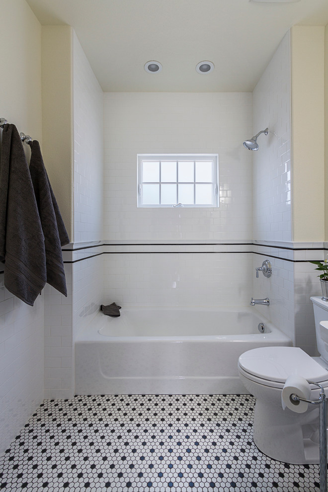 Photo of a small arts and crafts 3/4 bathroom in Phoenix with an alcove tub, a shower/bathtub combo, a two-piece toilet, black and white tile, subway tile, white walls, ceramic floors, a console sink and multi-coloured floor.