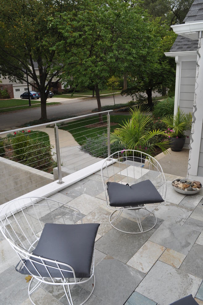 This is an example of a mid-sized contemporary rooftop partial sun garden for summer in Detroit with natural stone pavers.