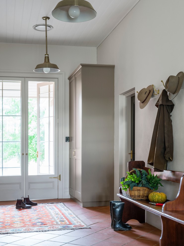 Design ideas for a large country mudroom in Sydney with white walls, terra-cotta floors, a single front door and a black front door.