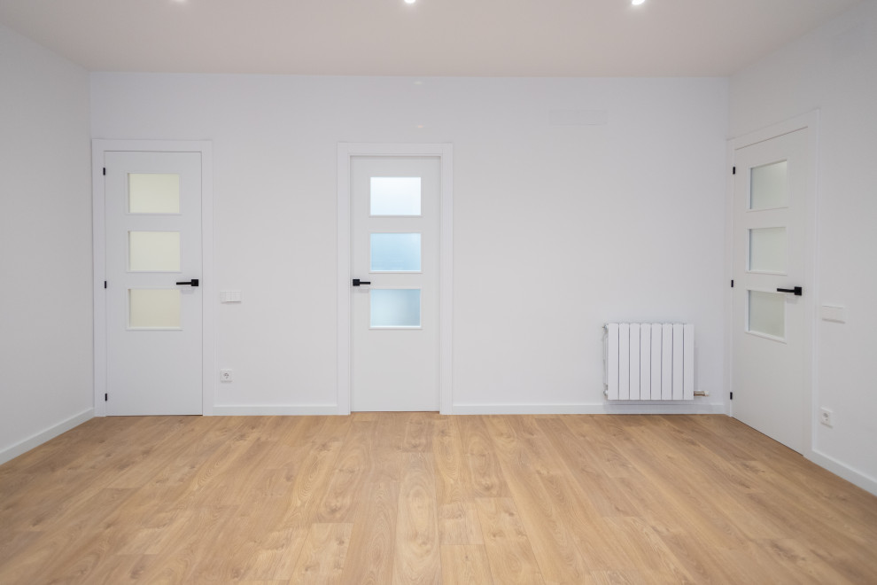 Imagen de salón cerrado nórdico de tamaño medio sin chimenea con paredes blancas, suelo de madera en tonos medios y suelo marrón
