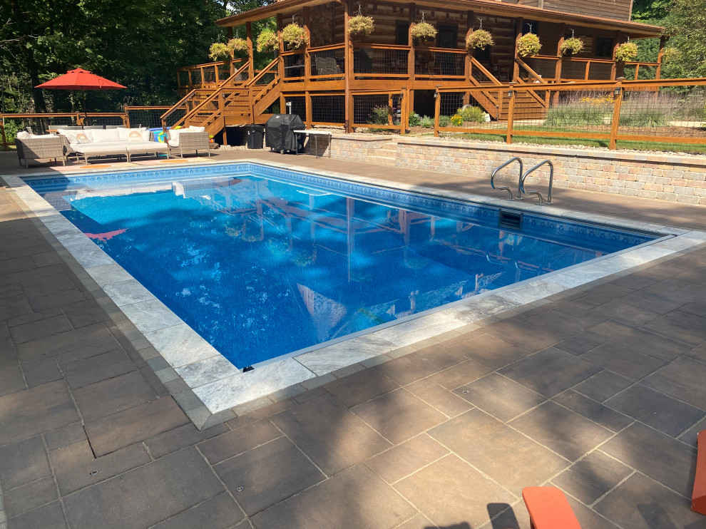 Idee per una grande piscina stile rurale rettangolare nel cortile laterale con paesaggistica bordo piscina e pavimentazioni in cemento