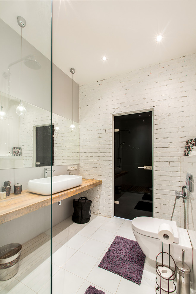 This is an example of a mid-sized industrial master bathroom in Moscow with a wall-mount toilet, white tile, porcelain tile, white walls, porcelain floors, wood benchtops, a vessel sink, an open shower and brown benchtops.