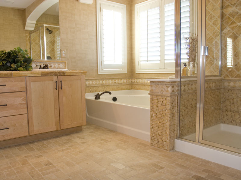 Inspiration for a large transitional master bathroom in Toronto with shaker cabinets, light wood cabinets, an alcove tub, a corner shower, brown tile, travertine, brown walls, travertine floors, a drop-in sink, tile benchtops, brown floor and a hinged shower door.
