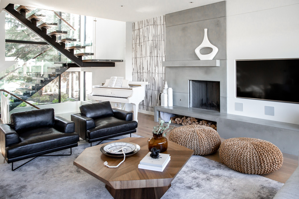 Inspiration for a large modern formal open concept living room in Calgary with white walls, light hardwood floors, a wood stove, a concrete fireplace surround, a built-in media wall and brown floor.