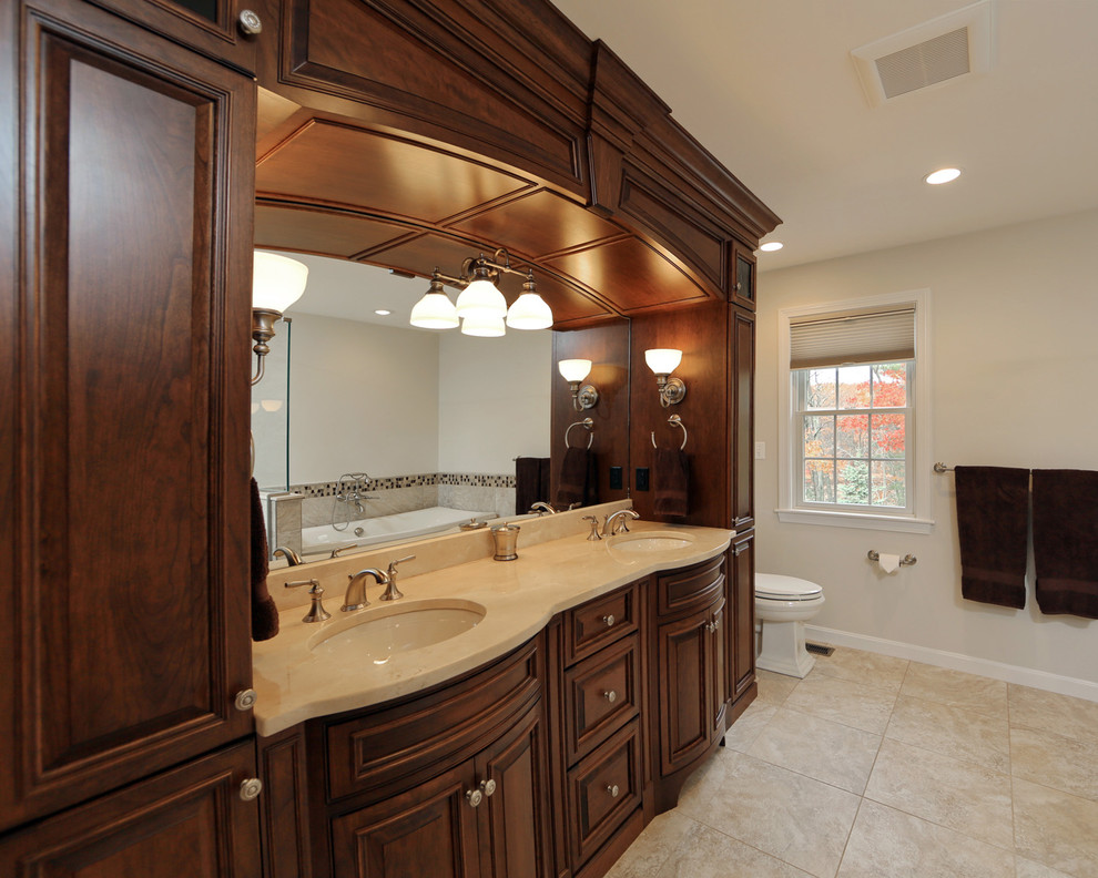 Large traditional master bathroom in Boston with furniture-like cabinets, dark wood cabinets, an undermount sink, granite benchtops, a freestanding tub, a corner shower, a one-piece toilet, beige tile, ceramic tile, beige walls and ceramic floors.