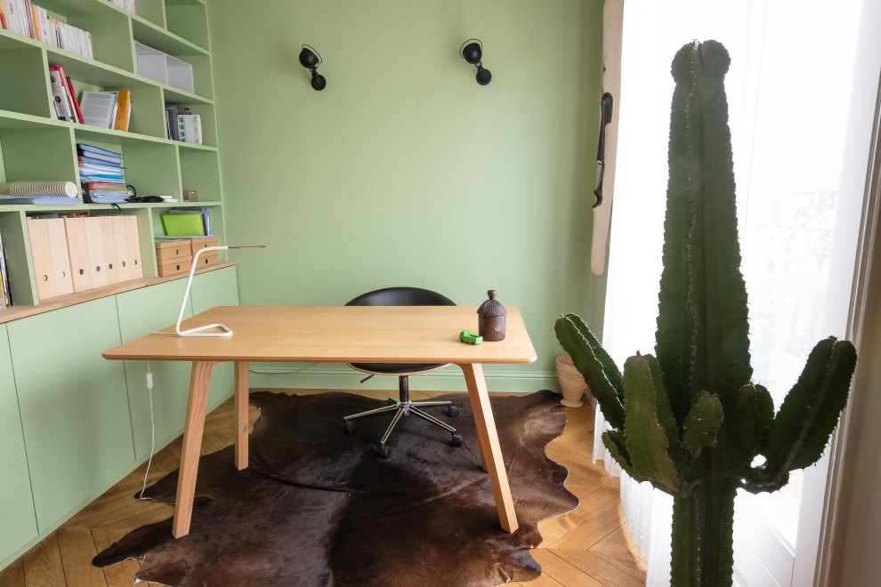 Стильный дизайн: рабочее место среднего размера в современном стиле с зелеными стенами, светлым паркетным полом, отдельно стоящим рабочим столом и бежевым полом - последний тренд