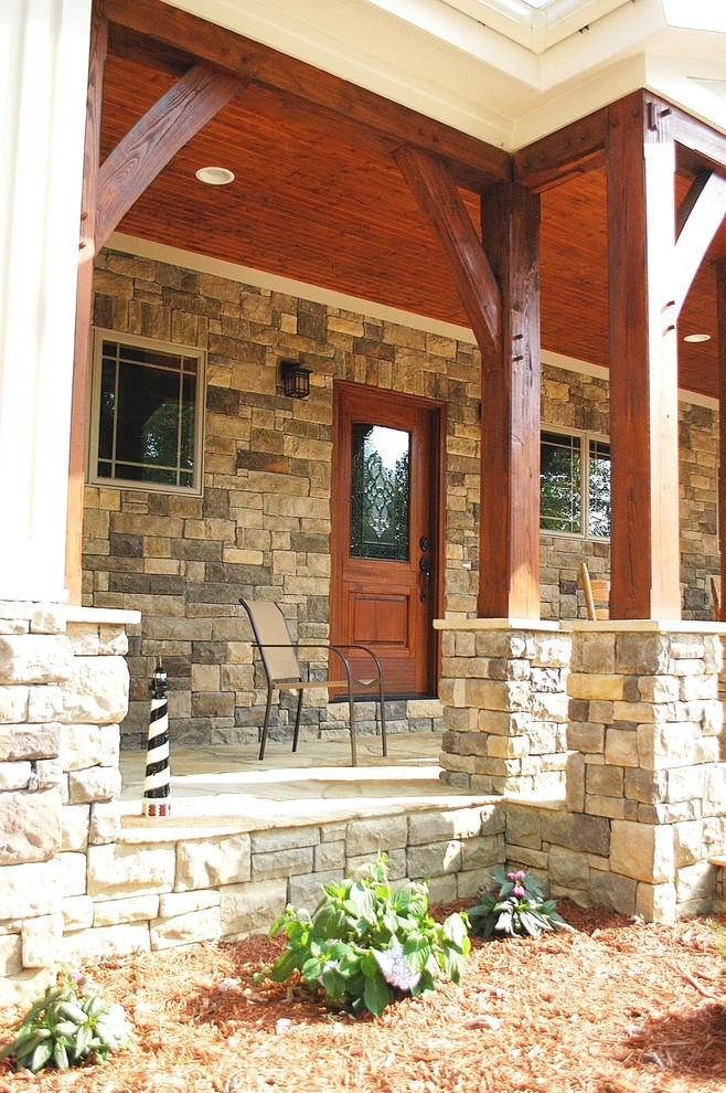 Photo of a mid-sized country two-storey grey exterior in Nashville with stone veneer and a gable roof.