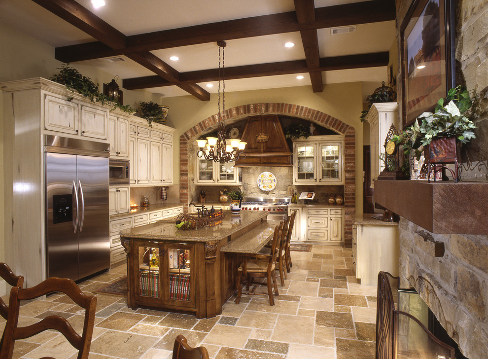 Eat-in kitchen - rustic galley ceramic tile eat-in kitchen idea in Houston with a farmhouse sink, raised-panel cabinets, distressed cabinets, granite countertops, brown backsplash, stone tile backsplash, stainless steel appliances, beige walls and an island