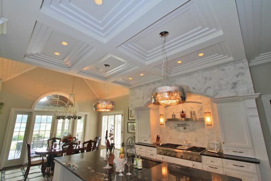 Inspiration for a mid-sized transitional galley eat-in kitchen remodel with a double-bowl sink, louvered cabinets, white cabinets, granite countertops, white backsplash, stone slab backsplash, stainless steel appliances and an island