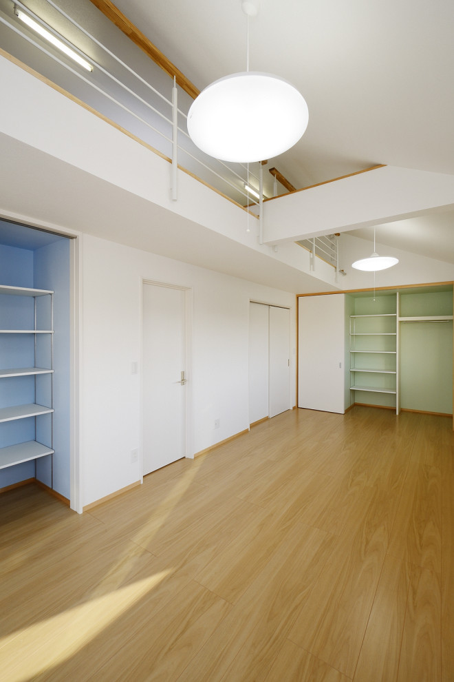 Esempio di una cameretta per bambini minimalista con pareti bianche, pavimento in legno massello medio, soffitto in carta da parati e carta da parati