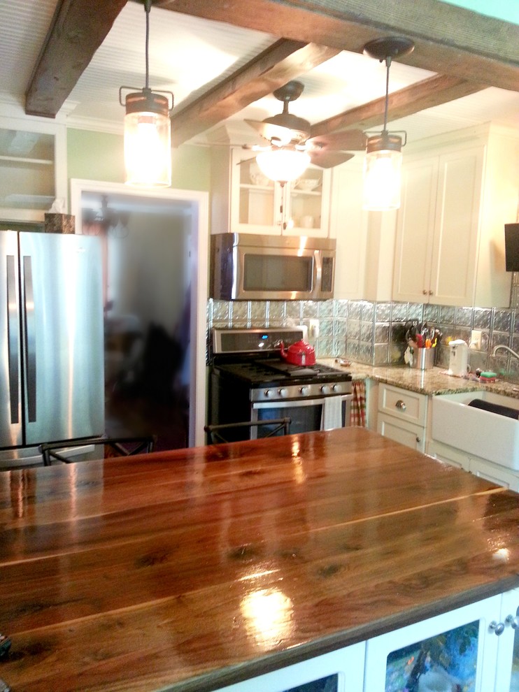 Eat-in kitchen - small rustic eat-in kitchen idea with a farmhouse sink, white cabinets, stainless steel appliances and an island