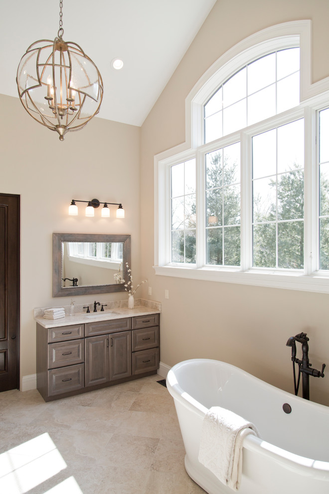 Design ideas for a large country master bathroom in St Louis with raised-panel cabinets, grey cabinets, a freestanding tub, a curbless shower, beige walls, ceramic floors, an undermount sink, granite benchtops, beige floor, an open shower and beige benchtops.