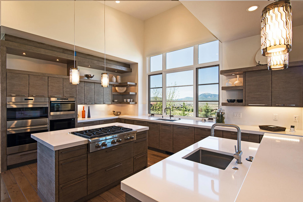 Inspiration for a contemporary u-shaped kitchen in Salt Lake City with an undermount sink, flat-panel cabinets, dark wood cabinets, stainless steel appliances, dark hardwood floors and with island.