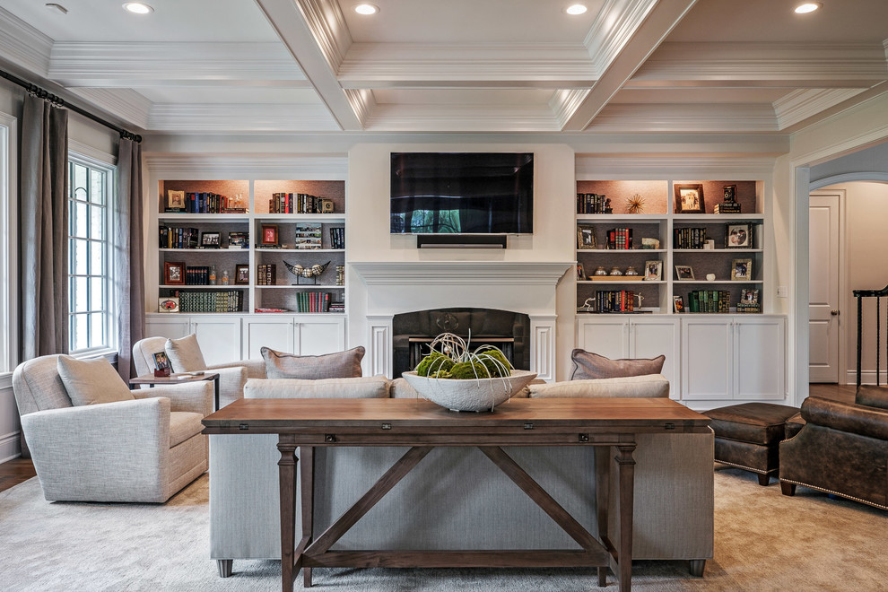 Example of a large classic enclosed carpeted and beige floor family room design in Other with beige walls, a standard fireplace, a plaster fireplace and a wall-mounted tv