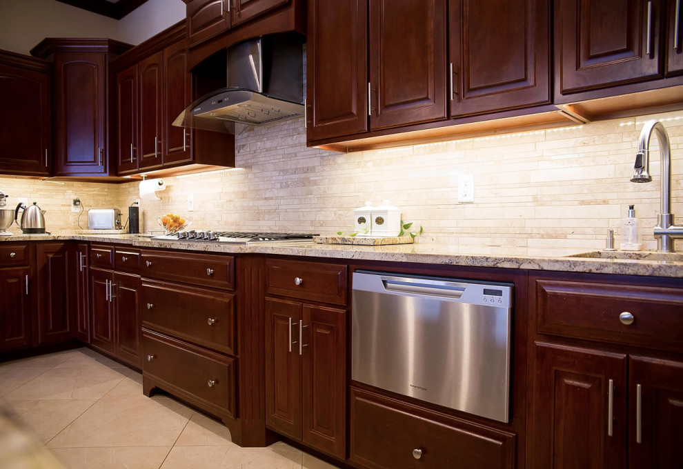 Example of a large minimalist u-shaped porcelain tile and beige floor open concept kitchen design with an undermount sink, raised-panel cabinets, dark wood cabinets, granite countertops, beige backsplash, matchstick tile backsplash, stainless steel appliances, an island and multicolored countertops