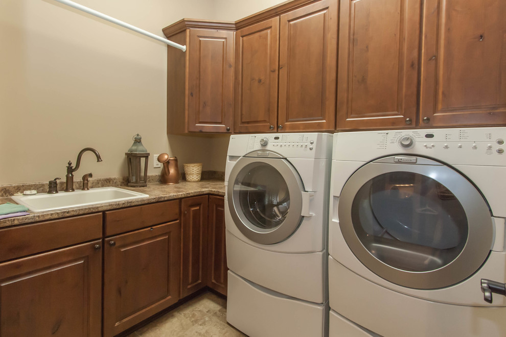 Design ideas for a mid-sized traditional dedicated laundry room in Other with a drop-in sink, medium wood cabinets and a side-by-side washer and dryer.