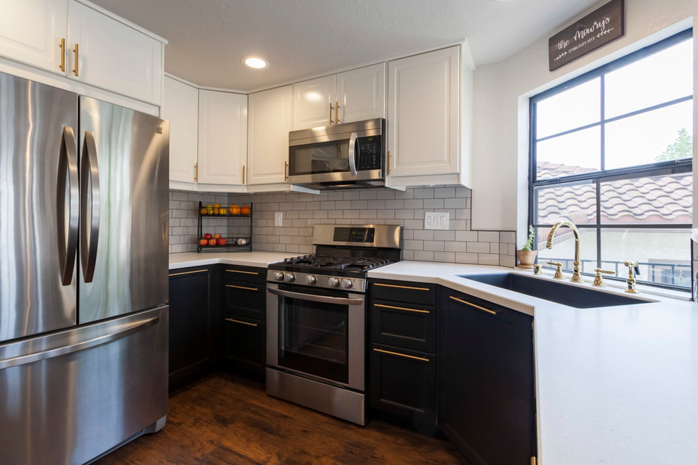 Example of a mid-sized transitional u-shaped medium tone wood floor and brown floor enclosed kitchen design in Los Angeles with an undermount sink, shaker cabinets, black cabinets, quartzite countertops, gray backsplash, ceramic backsplash, stainless steel appliances and no island