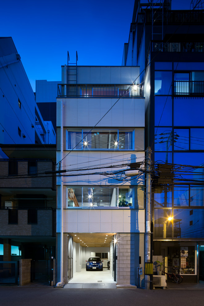 Photo of a small industrial three-storey white house exterior in Osaka with a flat roof.