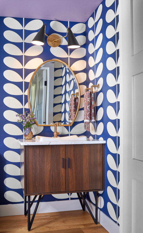 Inspiration for a midcentury powder room in Denver with furniture-like cabinets, dark wood cabinets, multi-coloured walls, light hardwood floors, a drop-in sink and white benchtops.