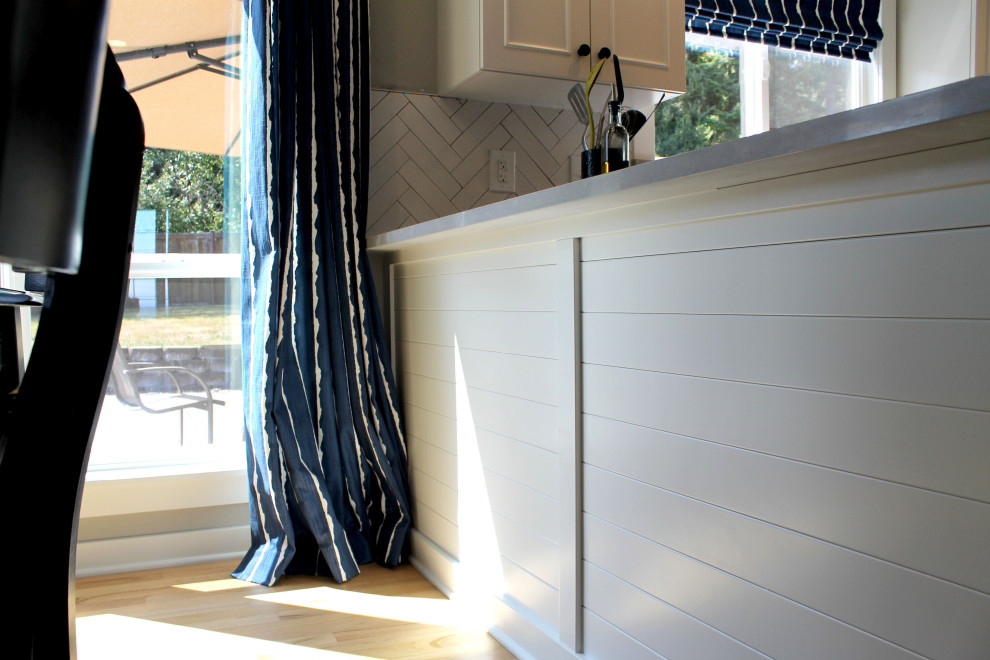 Example of a mid-sized transitional u-shaped medium tone wood floor eat-in kitchen design in Seattle with an undermount sink, shaker cabinets, white cabinets, quartz countertops, white backsplash, ceramic backsplash, stainless steel appliances, a peninsula and gray countertops