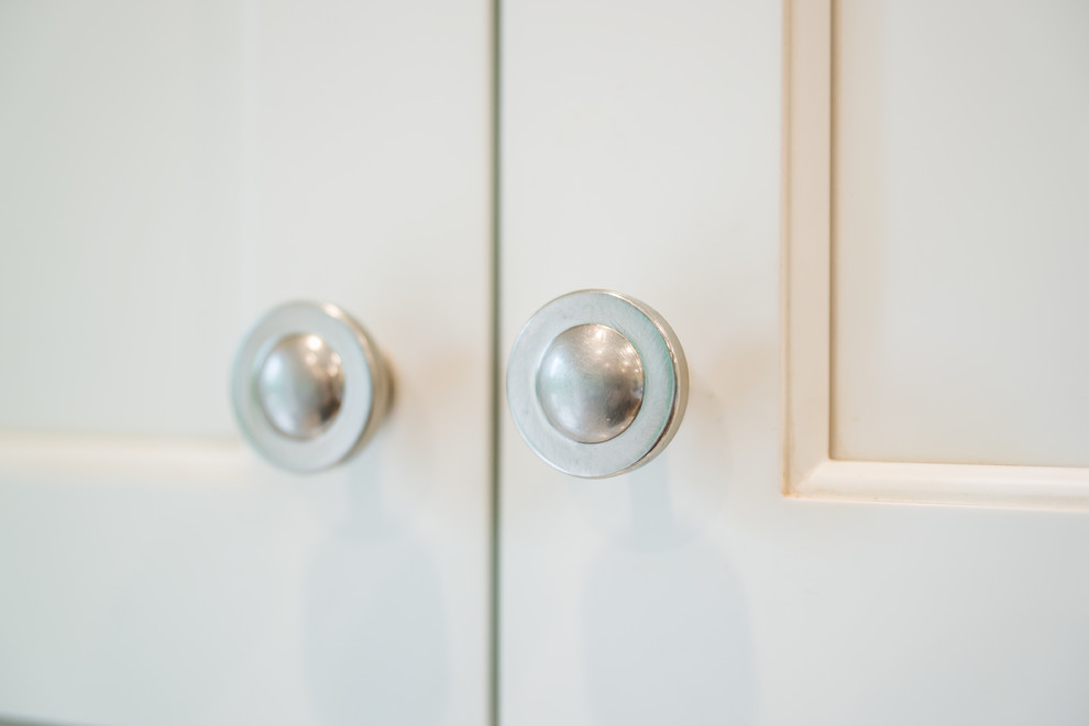Example of a transitional medium tone wood floor kitchen design in Birmingham with an undermount sink, recessed-panel cabinets, white cabinets, granite countertops, multicolored backsplash, glass tile backsplash, stainless steel appliances and an island
