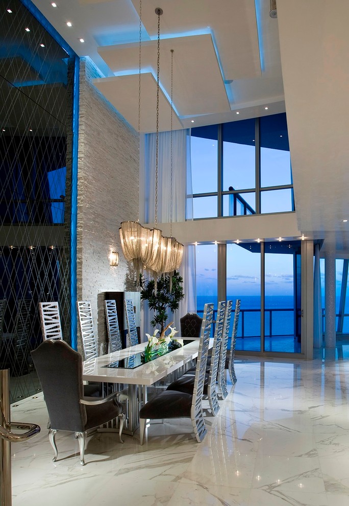 Photo of a contemporary dining room in Miami with white walls and marble floors.